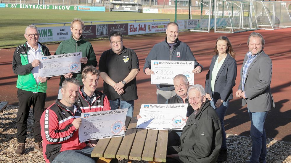 Freuen sich über einen großen Scheck und 8000 Euro: Folkert Reuter und Bernd Emkes vom SV Eintracht Ihlow (hinten links), Gert Fleßner und Reemt Mönck vom KBV Schirumer Leegmoor (vorne links), Norbert Eilers und Gerd Nessen von der Dorfgemeinschaft Popens (vorne rechts) und Christian Just vom SC Wiesens (Mitte). Überreicht wurden die Schecks von Jens Coordes (Mitte), Daniela Schuster und Udo Hippen (rechts). Foto: Romuald Banik