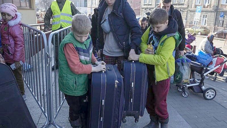 Ukrainische Flüchtlinge stehen am Bahnhof in Przemysl im äußersten Südosten Polen. Foto: Sergei Grits/AP/dpa