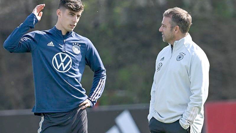 Bundestrainer Hansi Flick (r) spricht beim Training mit Kai Havertz. Foto: Arne Dedert/dpa