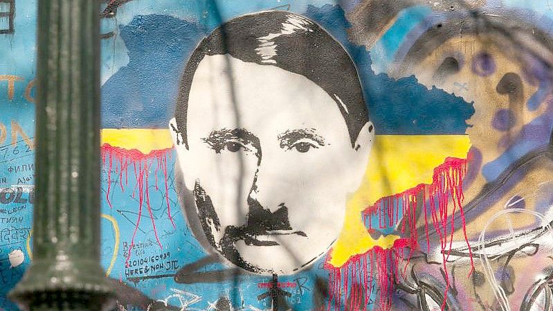 Auf der sogenannten John-Lennon-Mauer in Prag hat ein Unbekannter den russischen Präsidenten Wladimir Putin angesichts des Ukraine-Kriegs als Adolf Hitler dargestellt. Foto: Michael Heitmann/dpa
