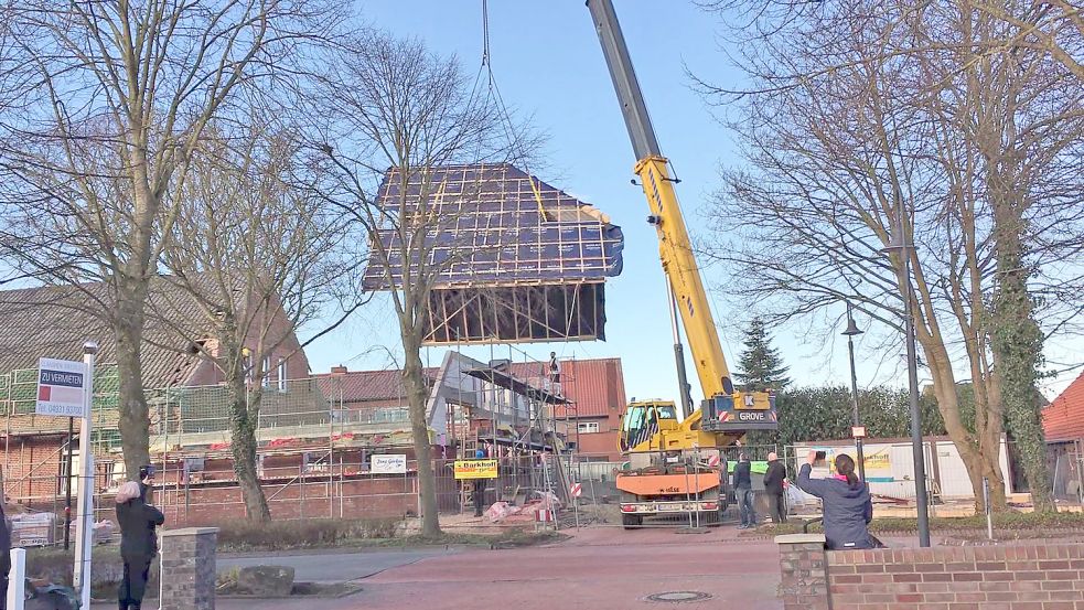 Im März 2021 hängt der am Boden zusammengebaute Dachstuhl für den neuen Teil des Gemeindehauses in Marienhafe am Ausleger eines Autokrans. Foto: privat