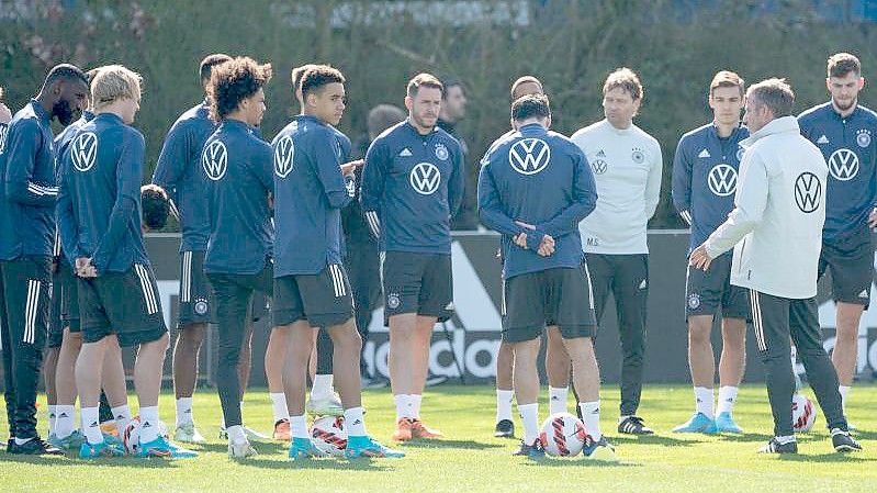 Bundestrainer Hansi Flick (r) wendet sich beim Abschlusstraining an die Spieler der Nationalmannschaft. Foto: Sebastian Gollnow/dpa