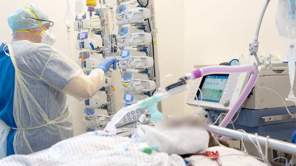 Ein Krankenpfleger versorgt einen schwer an Corona erkrankten Patienten auf der Intensivstation von einem Krankenhaus. Auch die Lage in den Kliniken in Aurich, Emden und Norden ist angespannt. Foto: DPA
