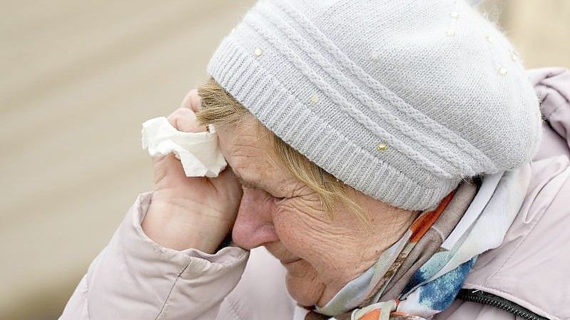 Eine Frau namens Swetlana, die aus Charkiw angereist ist, weint, während sie mit anderen Kriegsflüchtlingen aus der benachbarten Ukraine am polnischen Grenzübergang in Medyka in einer Schlange wartet. Foto: Sergei Grits/AP/dpa