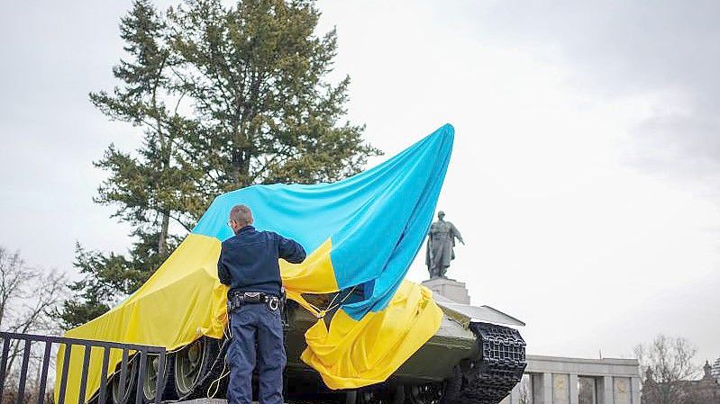 Polizeibeamte entfernen die Flagge der Ukraine von einem historischen Panzer am Sowjetischen Ehrenmal an der Straße des 17. Juni. Foto: Kay Nietfeld/dpa