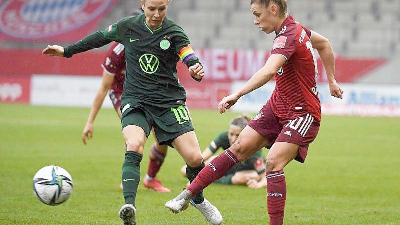 Linda Dallmann (r) spielt den Ball im Hinspiel vor der Wolfsburgerin Svenja Huth. Foto: Angelika Warmuth/dpa