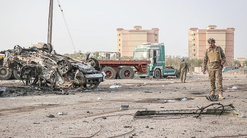 Ein Angehöriger der jemenitischen Sicherheitskräfte inspiziert ein zerstörtes Fahrzeug. Kurz nach dem Beginn der vereinbarten Waffenruhe im Jemen, werfen sich die Konfliktparteien aber bereits Verstöße vor. Foto: Wail Shaif/dpa