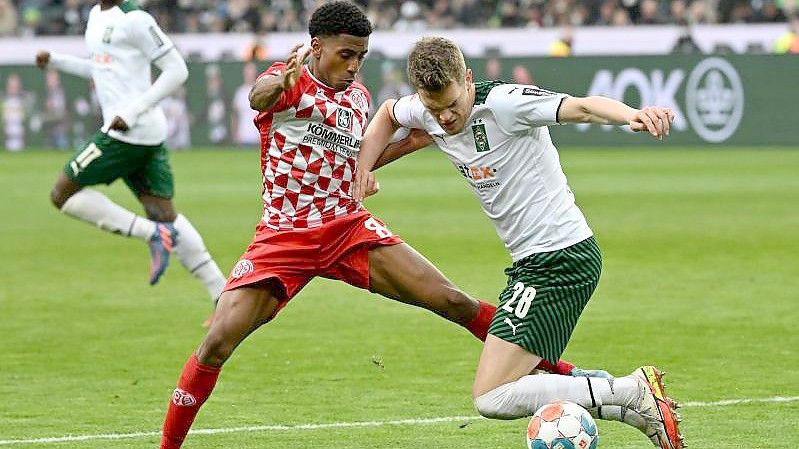 Der Mainzer Leandro Barreiro (l) bringt Mönchengladbachs Matthias Ginter zu Fall. Foto: Federico Gambarini/dpa