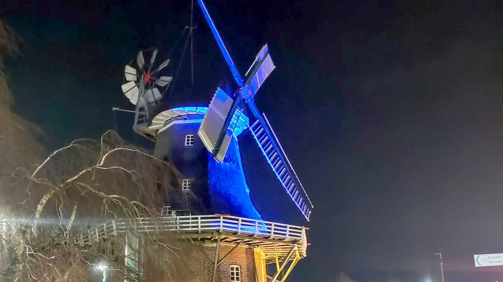 Die Mühle in Großefehn wird nachts in Blau und Gelb angestrahlt. Foto: Neelke Harms