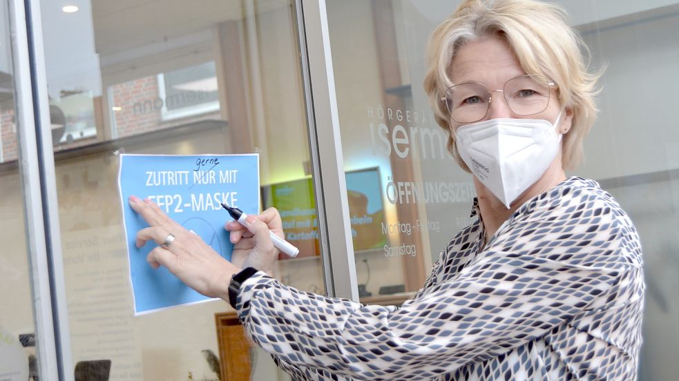 Rita Isermann veränderte am Montagvormittag das Schild am Eingang ihres Geschäfts in der Norderstraße in Aurich. Foto: Neelke Harms