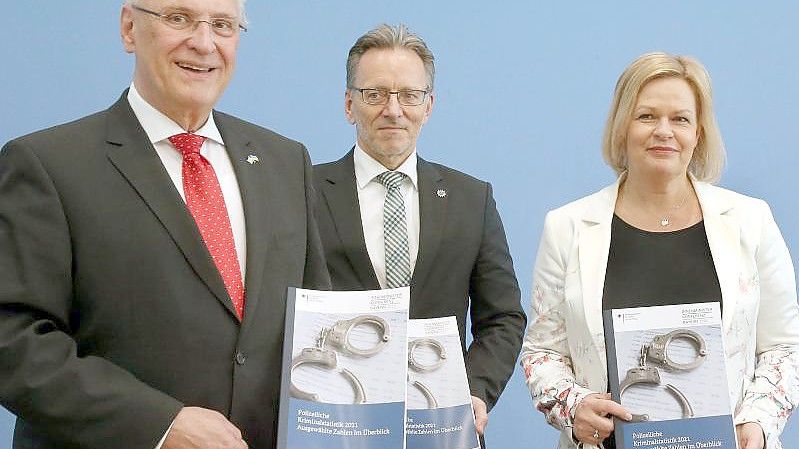 Der Bayerische Innenminister Joachim Herrmann, BKA-Präsident Holger Münch und Bundesinnenministerin Nancy Faeser stellen die Polizeiliche Kriminalstatistik 2021 vor. Foto: Wolfgang Kumm/dpa