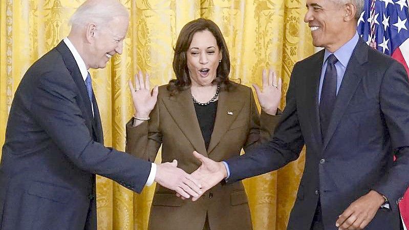 US-Vizepräsidentin Kamala Harris (M) reagiert auf den Handschlag von Präsident Joe Biden (l) und seinem Vorgänger Barack Obama. Foto: Carolyn Kaster/AP/dpa