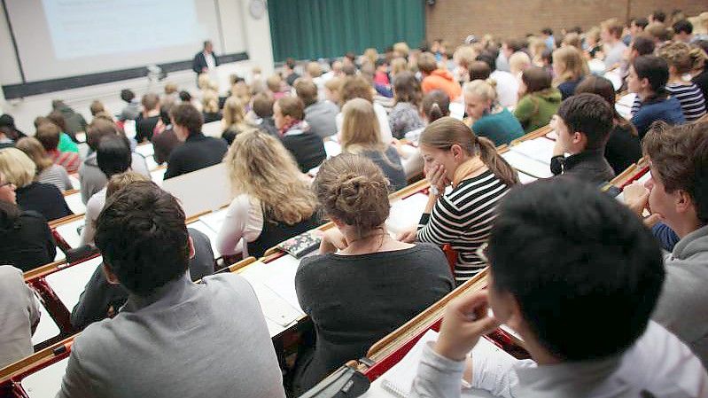 Studierende verfolgen eine Vorlesung an der Universität Köln. Bafög-Empfänger sollen zum Wintersemester fünf Prozent mehr Geld bekommen. Foto: Oliver Berg/dpa