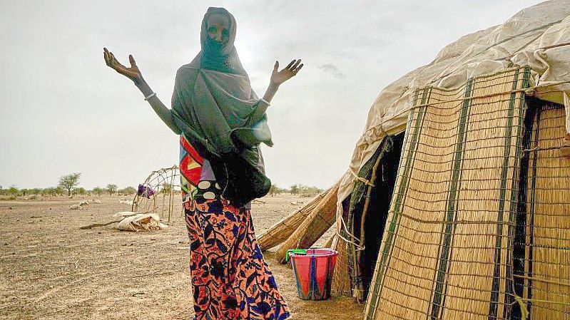 Eine Frau steht neben ihrer Hütte in einer von den Vereinten Nationen unterstützten Siedlung für Binnenflüchtlinge in Burkina Faso. Foto: Giles Clarke/UNOCHA/dpa