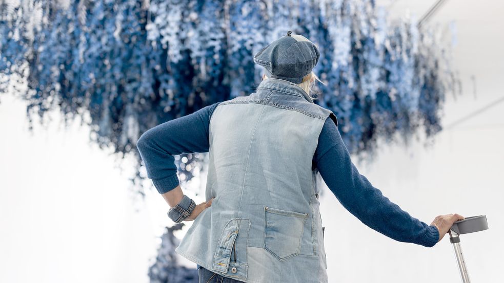 Co-Kuratorin Anne Marie Juli, die mit Studenten der Uni einen Raum in der Ausstellung gestaltet hat, betrachtet die Installation "Secret Garden" von Ian Berry. Die Ausstellung „BLUE JEANS – Kult. Kommerz. Kunst.“ im Kulturgeschichtlichen Museum in O Foto: Michael Gründel