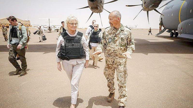 Bundesverteidigungsministerin Christine Lambrecht wird am Flughafen in Gao von Oberst Peter Küpper, dem Kontingentführer des deutschen Einsatzkontingents bei der UN-Mission Minusma, begrüßt. Foto: Kay Nietfeld/dpa