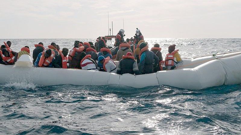 Menschen in einem in Not geratenen Schlauchboot, die von der Rettungsmannschaft „Sea-Watch 3“ an Bord genommen werden. (Archivbild). Foto: Max Brugger/Sea-Watch/dpa