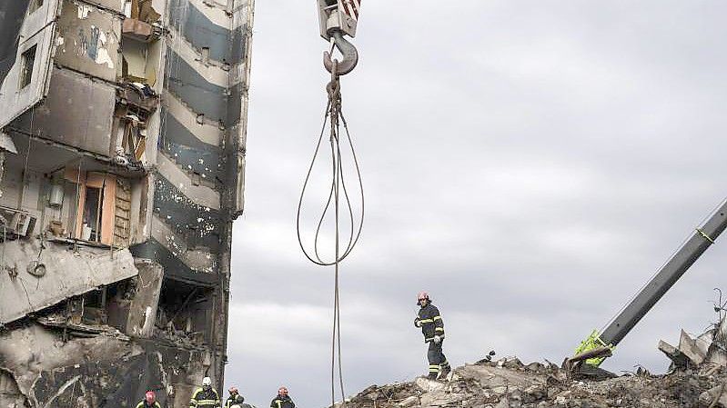 Ukrainische Feuerwehrleute arbeiten an einem durch russischen Beschuss zerstörten Wohnhaus in Borodjanka. Foto: Petros Giannakouris/AP/dpa