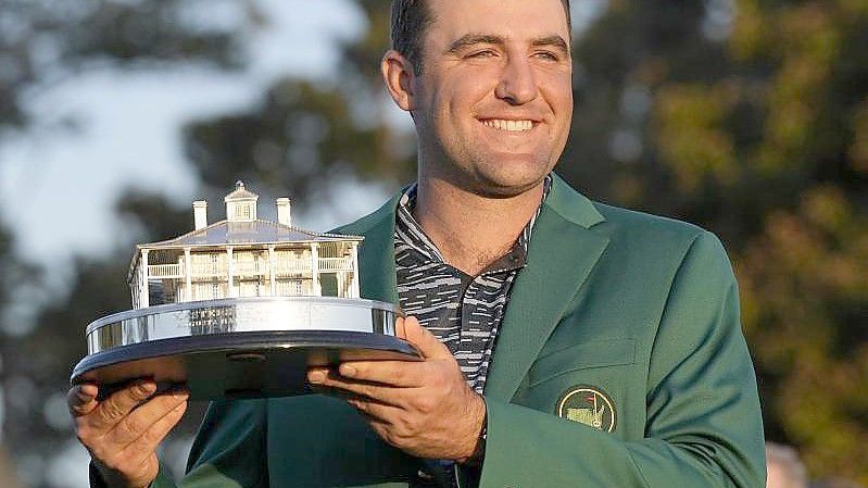 Sieger-Outfit: Scheffler im Grünen Jackett und mit dem Siegerpokal. Foto: David J. Phillip/AP/dpa