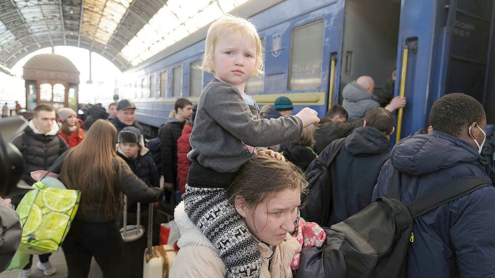 Eine Frau trägt ihr Kind am Bahnhof von Lwiw. Foto: DPA