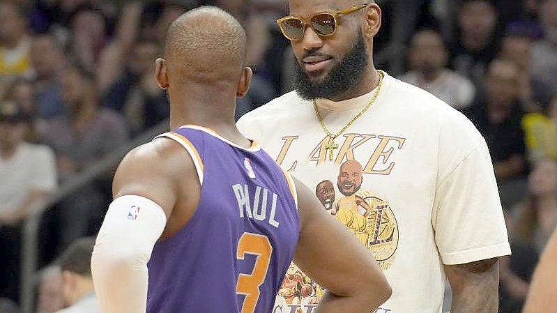 Lakers-Star LeBron James (r) ist bei den diesjährigen NBA-Playoffs nur Zuschauer - Chris Paul mit den Phoenix Suns dabei. Foto: Rick Scuteri/AP/dpa