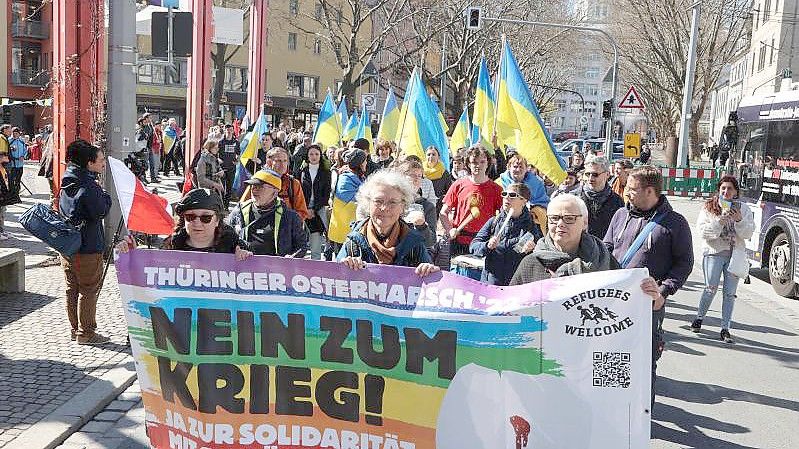 Teilnehmer eines Ostermarsches laufen in Jena nach einer Kundgebung auf dem Holzmarkt durch die Innenstadt. Foto: Bodo Schackow/dpa