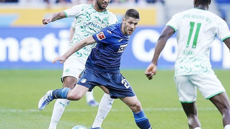 Fürths Timothy Tillman (l) und Hoffenheims Andrej Kramaric kämpfen um den Ball. Foto: Uwe Anspach/dpa