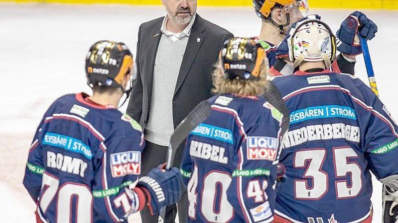 Berlins Cheftrainer Serge Aubin (2.v.l) unterhält sich nach einem Spiel mit seinen Spielern auf dem Eis. Foto: Andreas Gora/dpa