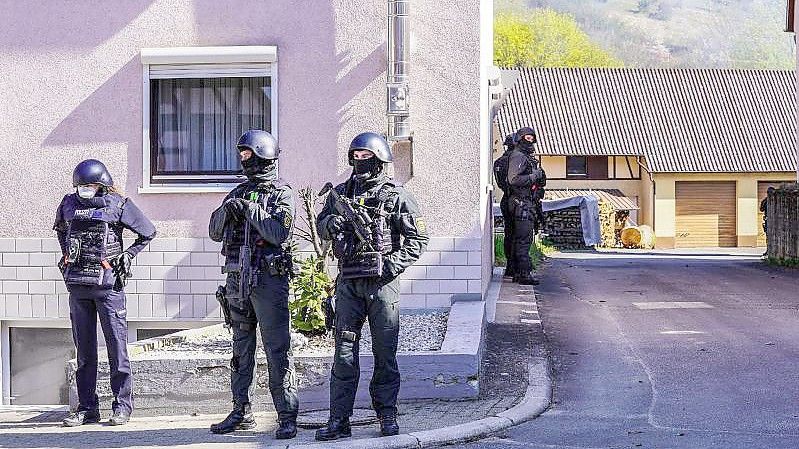 Bewaffnete Polizisten umziegeln ein Haus in Boxberg. Foto: Kohls/SDMG/dpa