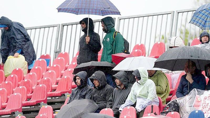 Fans sitzen während des Freien Trainings mit Regenschirmen auf der Tribüne. Foto: David Davies/PA Wire/dpa