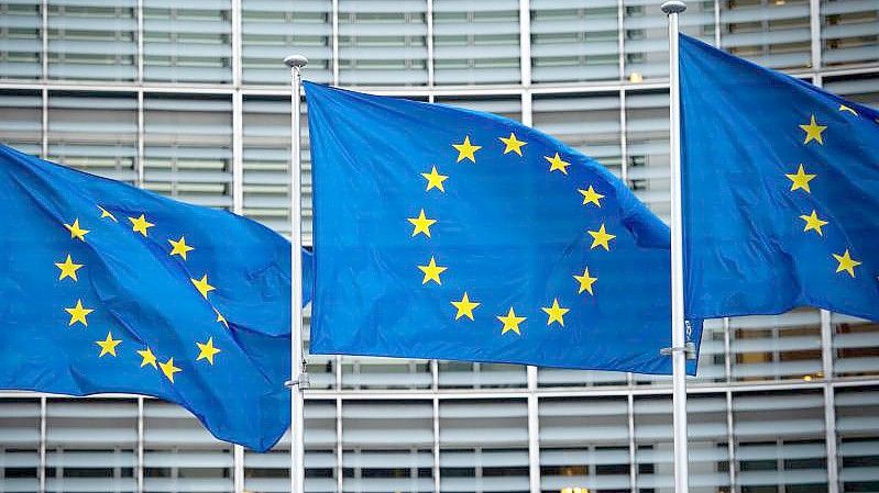 Flaggen der Europäischen Union wehen im Wind vor dem Berlaymont-Gebäude der Europäischen Kommission in Brüssel. Foto: Arne Immanuel Bänsch/dpa