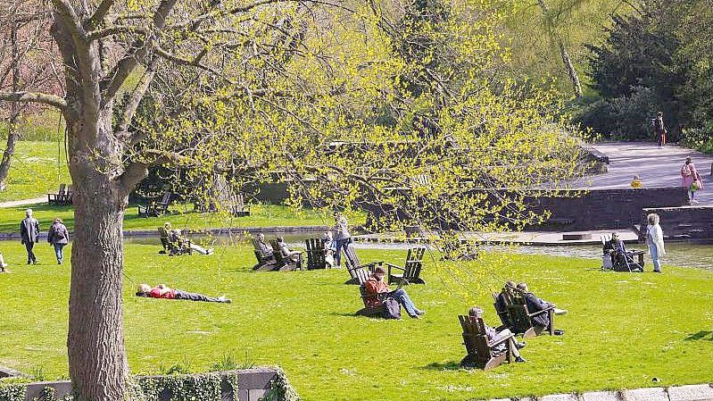 Menschen genießen in Hamburg die Sonne. Foto: Ulrich Perrey/dpa