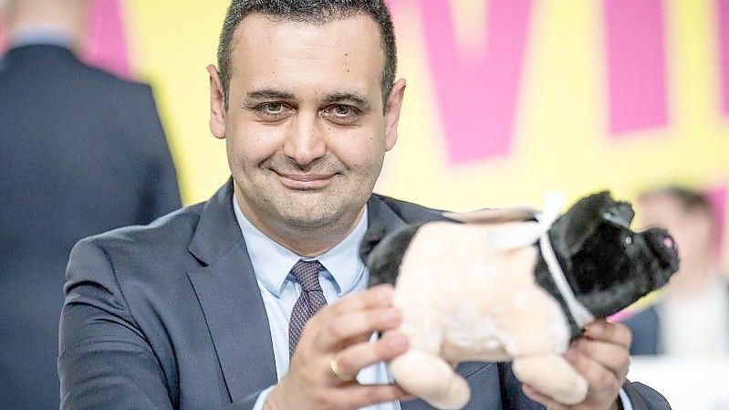 Der neugewählte FDP-Generalsekretär Bijan Djir-Sarai präsentiert ein geschenktes Glücksschwein. Foto: Michael Kappeler/dpa