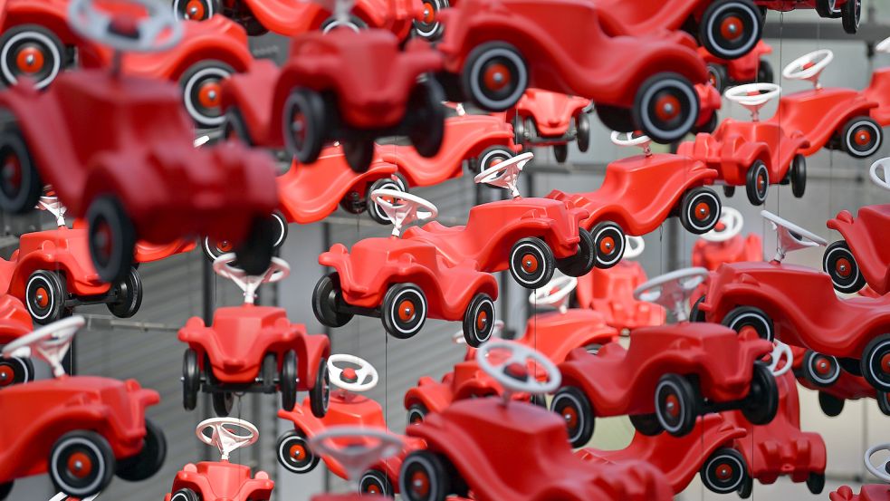 Das Bobby-Car ist Kult – hier haben Künstler das Rutschauto in einer fliegenden Installation arrangiert. Foto: Hendrik Schmidt/dpa