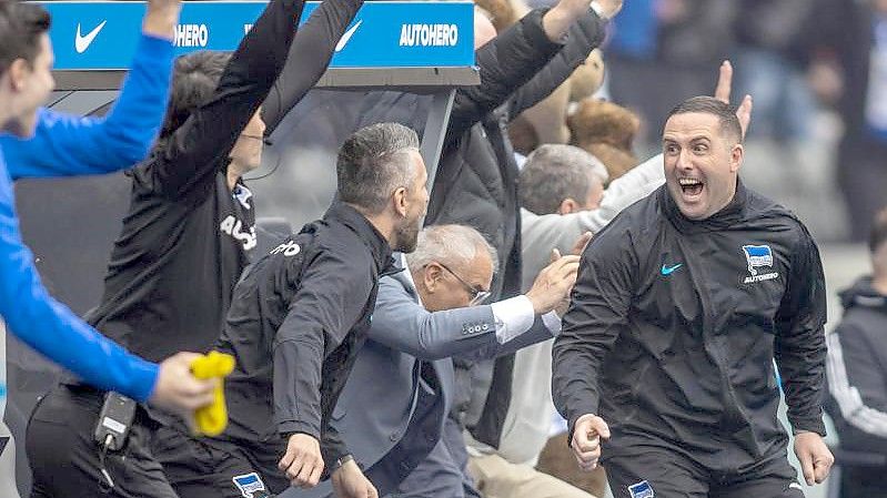 Das Trainerteam von Hertha BSC feiert den Führungstreffer. Foto: Andreas Gora/dpa