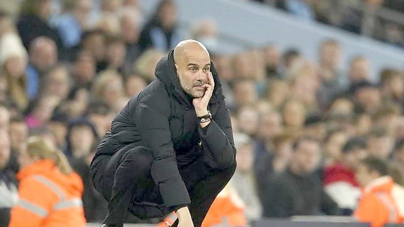 Pep Guardiola, Trainer von Manchester City, hockt an der Seitenlinie und studiert das Spiel seiner Mannschaft. Foto: Dave Thompson/AP/dpa