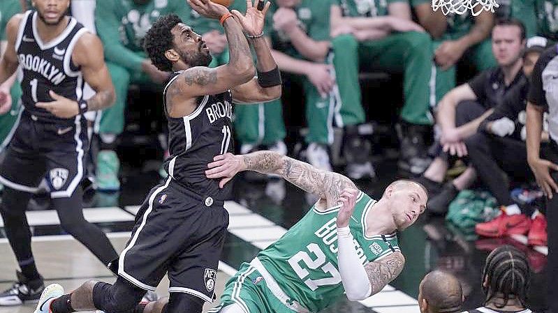 Kyrie Irving (M, l) von Brooklyn foult Daniel Theis (M, r) von Boston. Foto: John Minchillo/AP/dpa