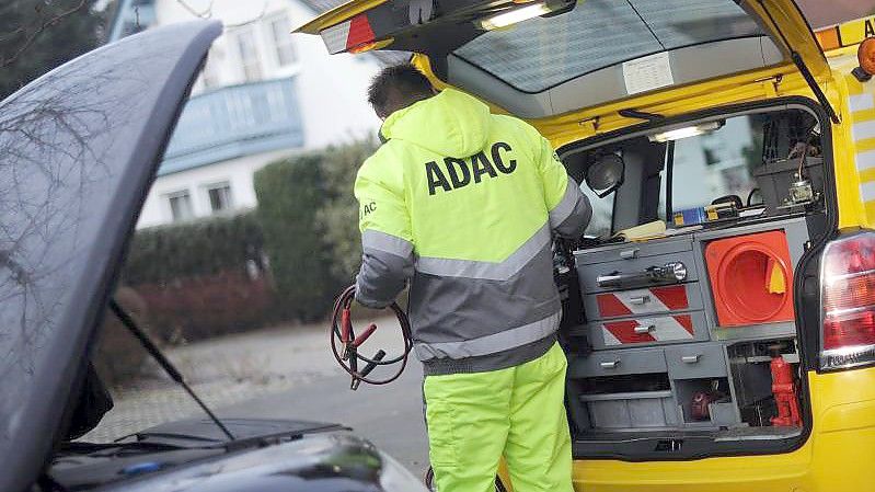 Ein ADAC-Pannenhelfer mit Starthilfekabel im Einsatz. Foto: picture alliance / dpa