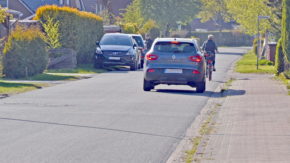 Eine Radfahrerin und ein Auto fahren am Donnerstagabend auf dem Ritzweg in Moordorf. Foto: Franziska Otto
