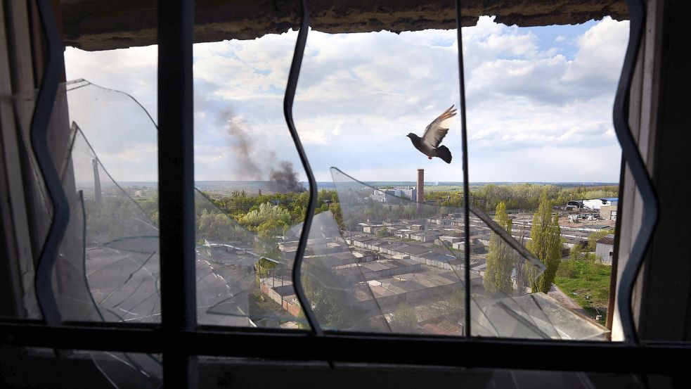 Blick aus dem zerstörten Fenster eines Gebäudes in der ukrainischen Stadt Charkiw. Foto: DPA
