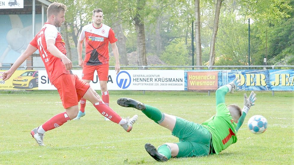 SVG-Spieler Tobias Hillers (links) schiebt den Ball vorbei am Auricher Torwart Pascal de Buhr. Im Hintergrund verfolgt der Fehntjer Stürmer Hauke Specht den Treffer zum zwischenzeitlichen 3:1 gegen die SpVg Aurich. Foto: Bernd Wolfenberg