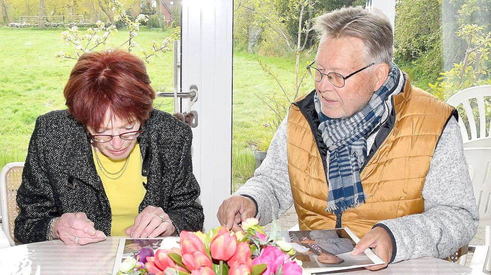 Vorsitzender Reinhardt Jensen und seine Stellvertreterin Elwine Cremer sehen sich Alben an und schwelgen in Erinnerungen. Foto: Gerd-Arnold Ubben