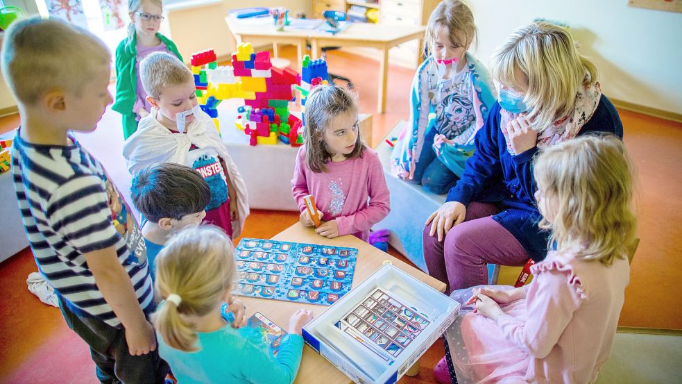 Eine Erzieherin mit Kindern einer Vorschulgruppe. Foto: Jens Büttner/DPA