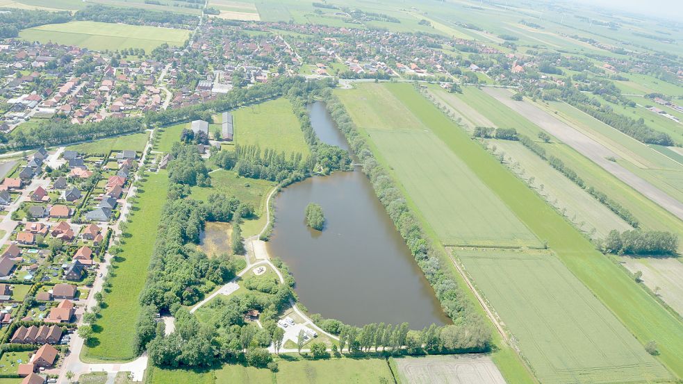 Das neue Sportzentrum in Marienhafe soll auf einer bisher landwirtschaftlich genutzten Flächen nördlich des Kiessees am Tjücher Moortun (im Bild parallel rechts zu den Wasserflächen) entstehen. Landwirte, die das daran angrenzende Land bewirtschaften, haben dagegen Bedenken vorgebracht. Foto: Thomas Dirks