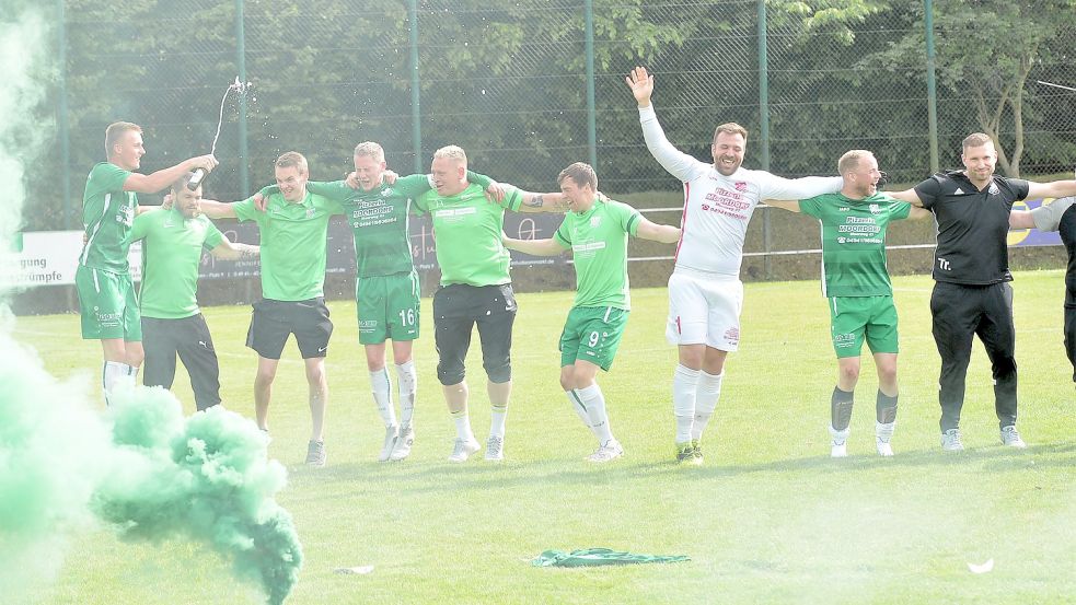 „Nie mehr Ostfrieslandliga“: Mannschaft und Trainer Dennis Debelts (rechts) feierten nach dem 1:1 den Aufstieg in die Bezirksliga.Fotos: Bernd Wolfenberg