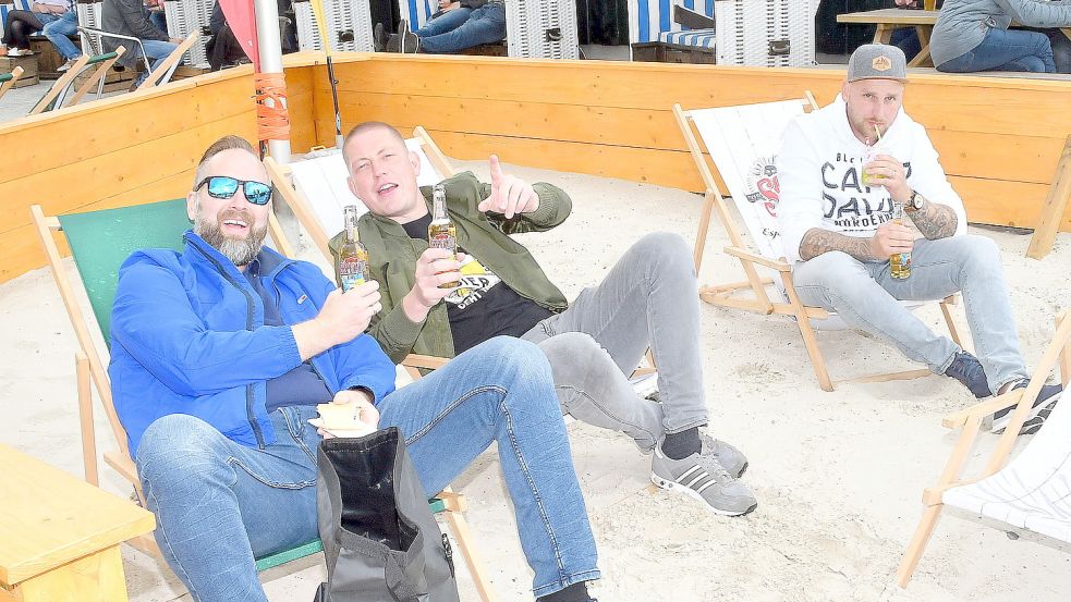 Diese drei Moormerländer aus Neukamperfehn fühlten sich vor dem „Pick Up Beach Club“ am Timmeler Strand sichtlich wohl. Foto: Gerd-Arnold Ubben