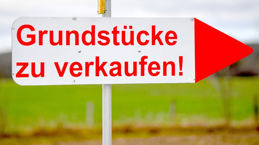 Ein Schild mit der Aufschrift „Grundstücke zu verkaufen!“ steht an einer Straße. In Ihlow soll die Vergabe von Grundstücken über einen Punktekatalog geregelt werden. Foto: DPA