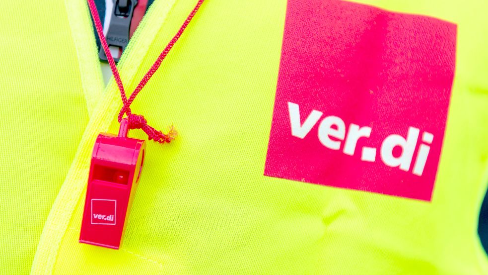 Ein Streikender trägt bei einer Demonstration eine Warnweste mit dem Verdi-Logo und eine rote Trillerpfeife. Foto: DPA