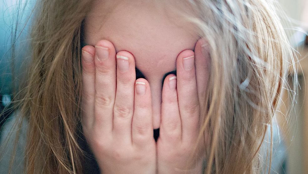 Ein junges Mädchen hält sich die Hände vor ihr Gesicht. Mentale Erschöpfung und Depressionen sind derzeit bei Kindern und Jugendlichen keine Seltenheit mehr. Foto: DPA