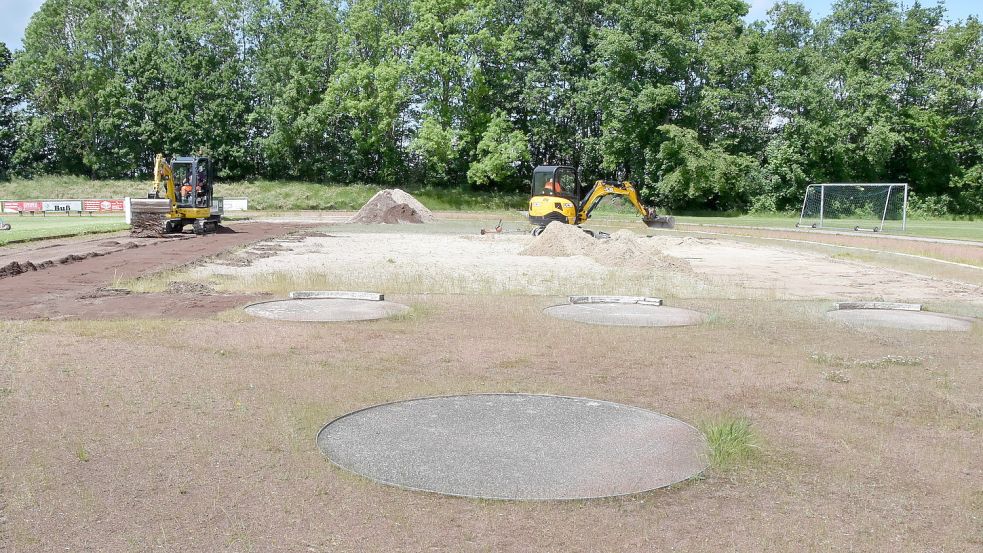 Mit gleich zwei Baggern bearbeiteten Bauhofmitarbeiter am Donnerstag das Umfeld der Sprunggrube auf dem Sportplatz in Upgant-Schott. Foto: Thomas Dirks